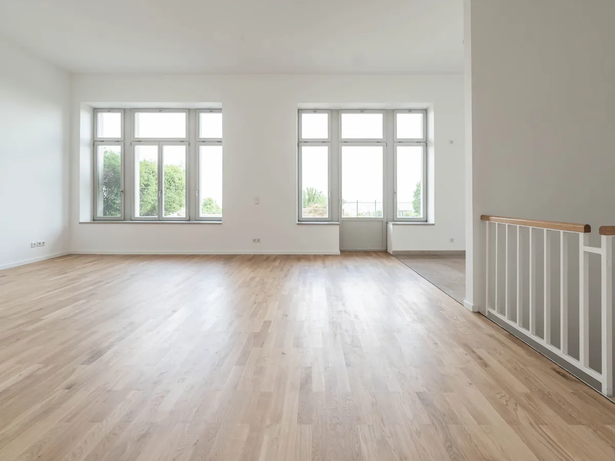 Sanierter Wohnraum: Eichenparkett, glatte weiße Wände, große Fenster