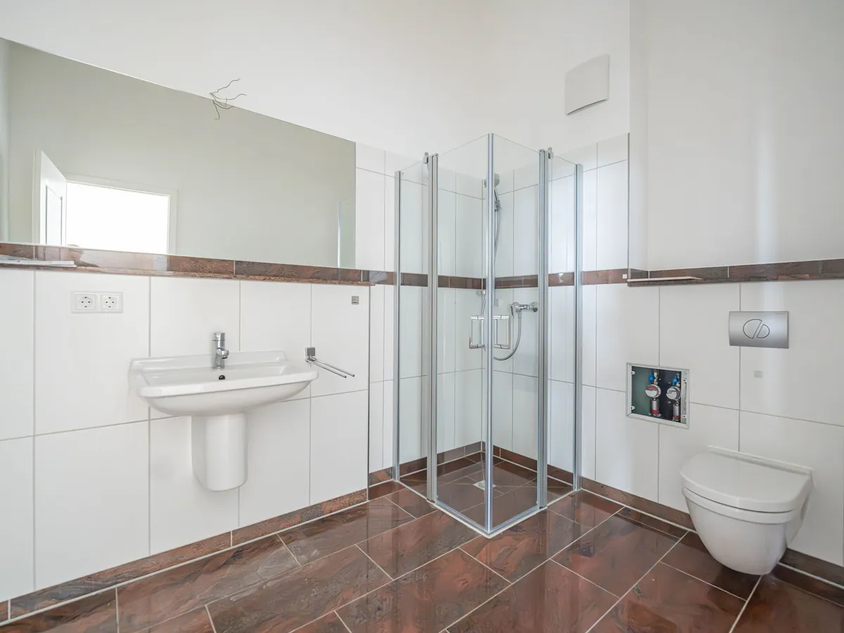 Bad nach der Sanierung: Walk-in-Dusche, großformatige Fliesen, Waschtisch mit Unterschrank